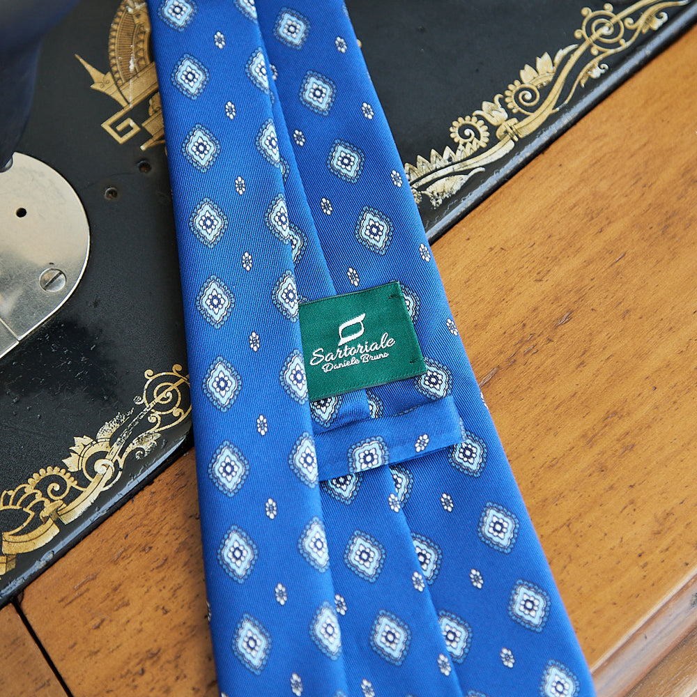 
                  
                    Fantasy tie in electric blue pure silk with blue and white design
                  
                